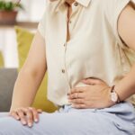 Woman with stomach ache: How to Get Rid of Bloating After Thanksgiving Indulgence