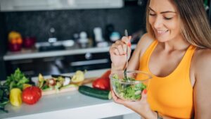 One fit woman eating healthy vegetable salad for breakfast