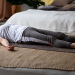 A mature woman lying on a yoga mat at home after gentle exercise during menopause recovery.