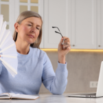 Woman experiencing a menopause hot flash while working on a laptop at home