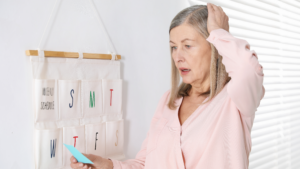 Woman experiencing menopause brain fog while looking at a note beside a weekly schedule.